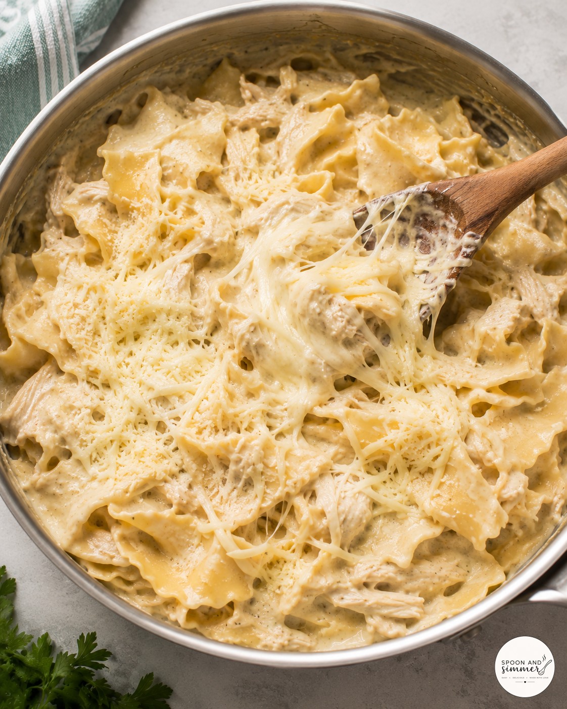 Broken lasagna noodles simmering in creamy broth for white chicken skillet lasagna