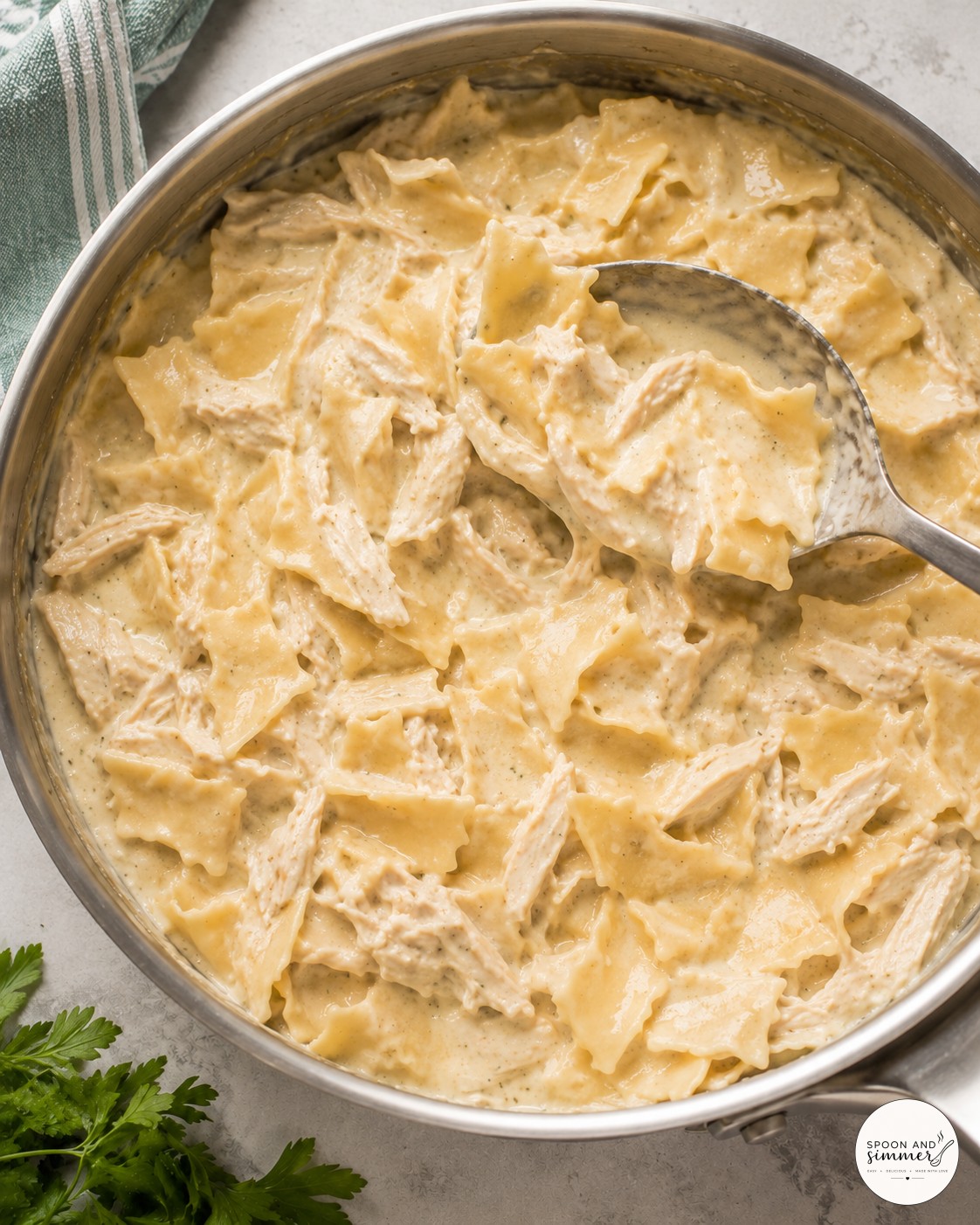 Broth and cream being poured into the skillet for a creamy white chicken skillet lasagna sauce
